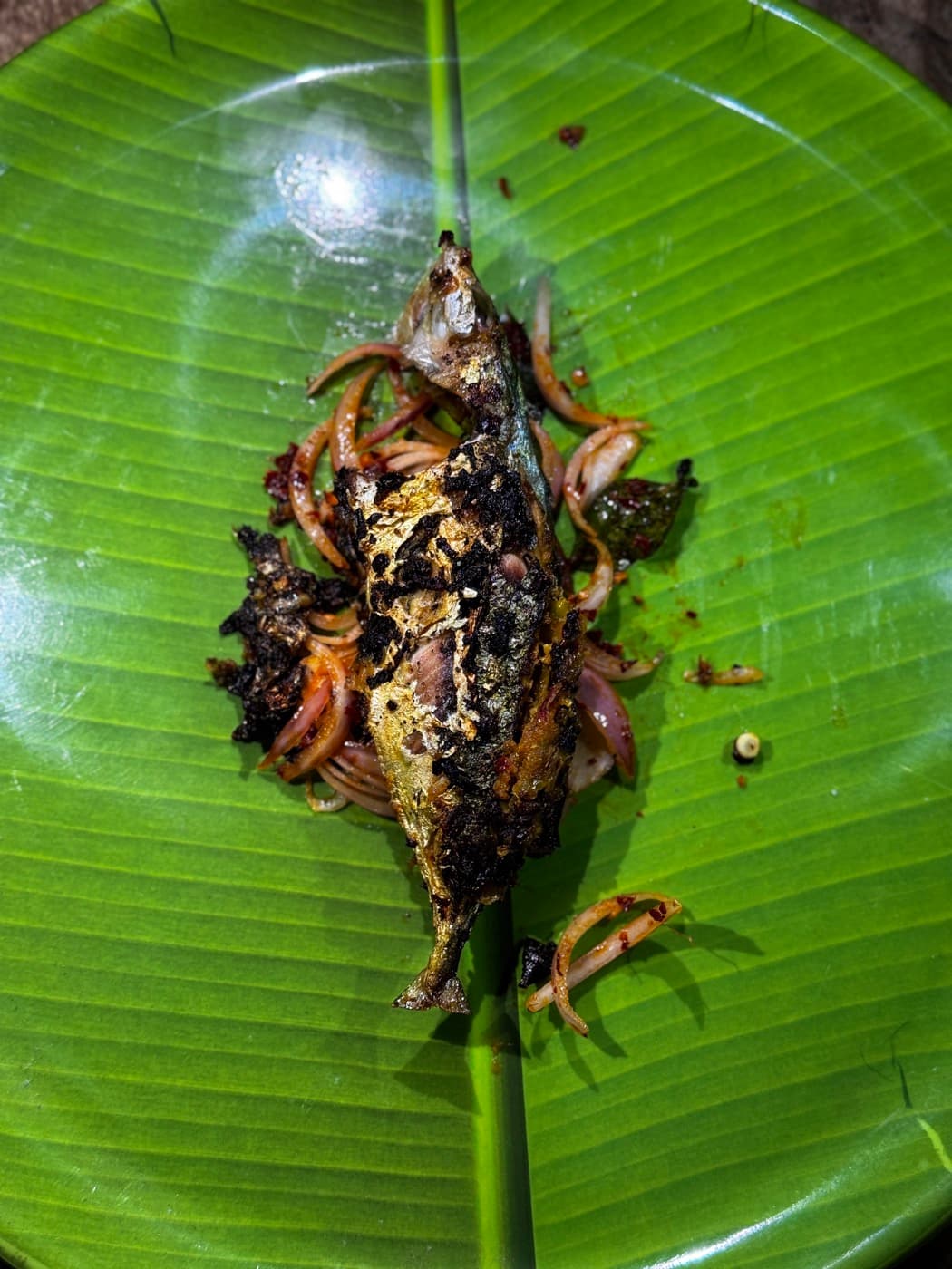 Spiced ayala fish served on a bright green banana leaf